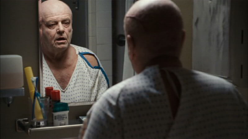 Bald man looking at himself in the mirror